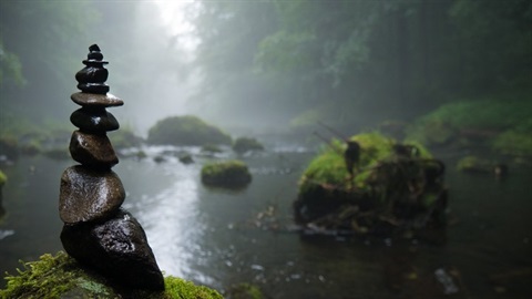 Stacked rocks in a foggy stream