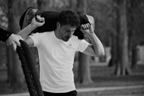 man holding a weight sack on his back